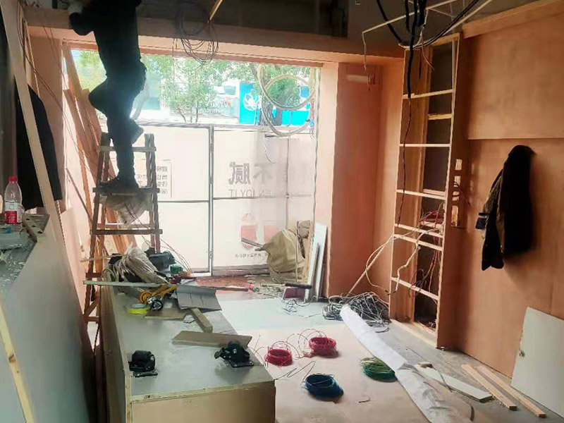 門店木工施工現場:首先應該搭建木作施工臺。木作施工臺用于板材的切割板，板材的造型，板材的平整度處理等等。門窗的制作包括門窗套制作、門窗制作。要特別注意門窗扇與框之間的縫隙不能太大，以及門窗套與門窗的色差等。木作表層封裝木制品制作完成后，對其表面進行細節封裝。木作表層封裝通常就要用到各種各樣的家裝板材，特別注意板材的選購。